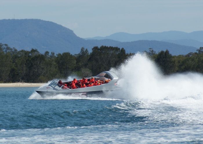A jet boat zooms across the water at Lake Macquarie